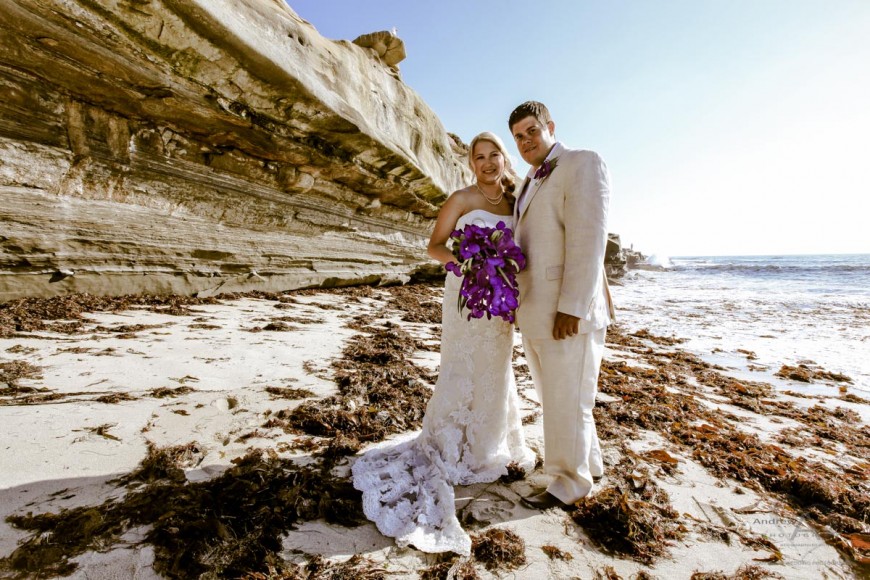 Bride and Groom on beach with purple bouquet purple corsage and sea cliff by San Diego Wedding Photographer Andrew Abouna